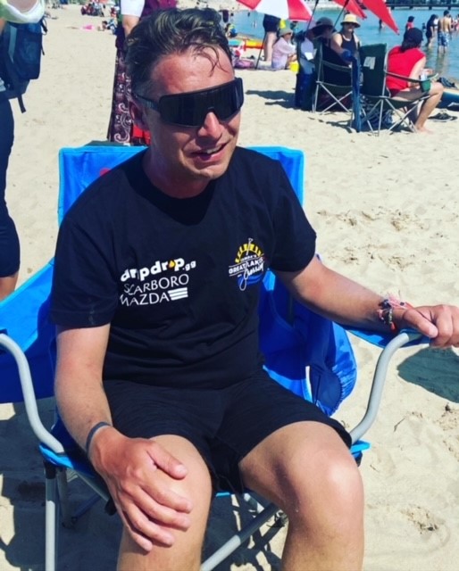 Mike Shoreman in chair on shore Mike Shoreman sitting in a chair on shore wearing black sunglasses and a black t-shirt