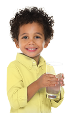 Boy with curly hair holding a glass of water