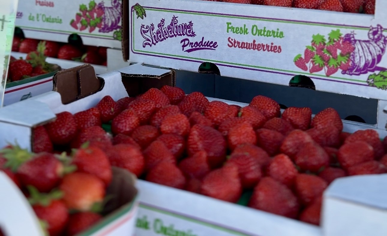 Image of flats of strawberries stacked high at a farmer's market