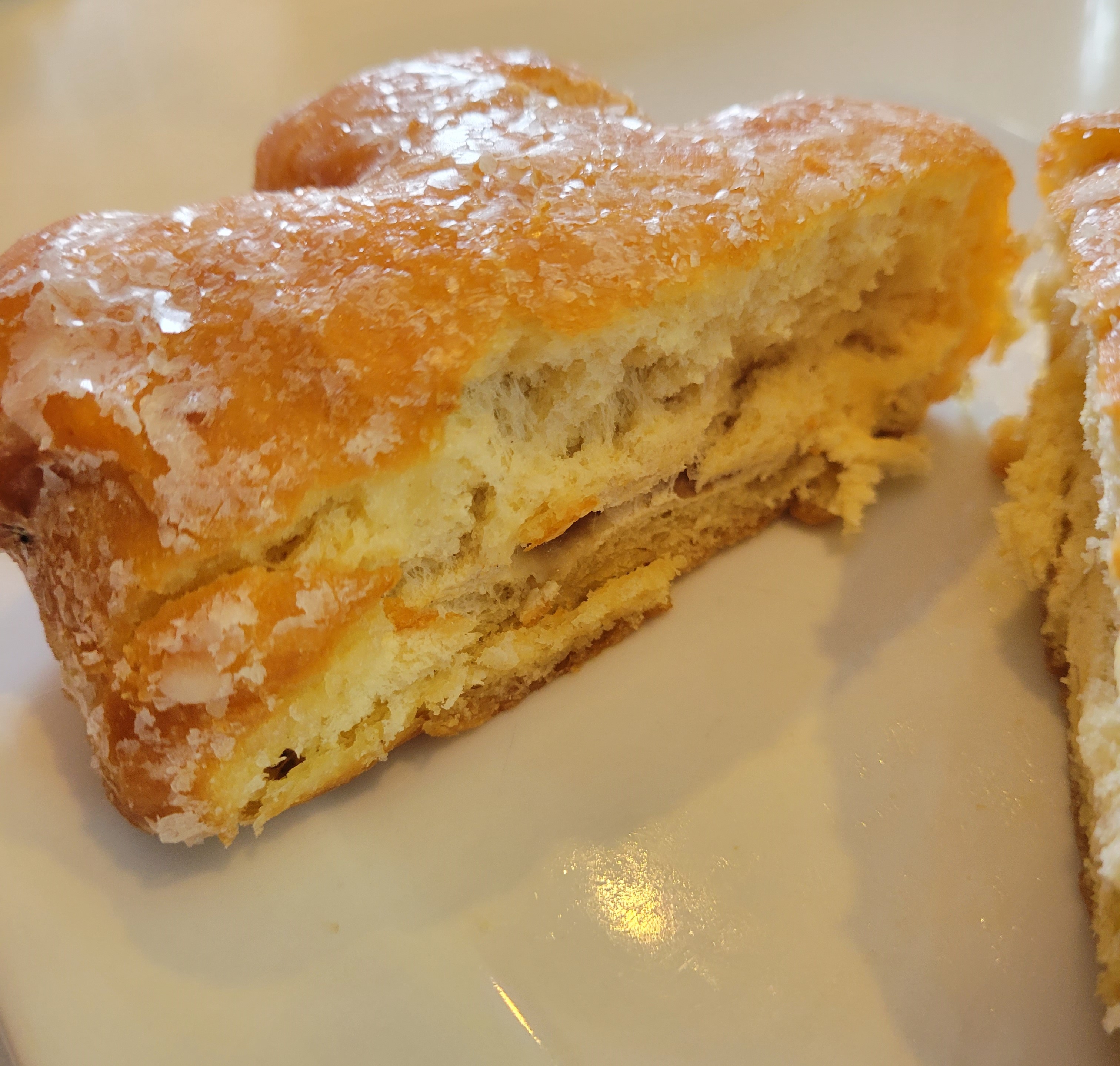 Hollywood Donuts apple fritter Hollywood Donuts apple fritter served on a white plate and cut in half