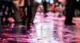 Wet street with people walking and lights in the distance