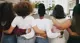 A group of people with the arms linked behind their back.