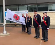 Regional Councillor for Oshawa, Bob Chapman; Regional Chair, John Henry; Zone F1 Commander, Myrna Picotte; and local Legion branch Presidents holding the Poppy Flag and Regional Headquarters following a flag raising ceremony for the start of the Legion’s annual Poppy Campaign.