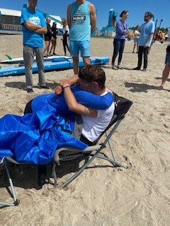 Mike Shoreman hug on shore woman Mike Shoreman receives a hug while sitting in a chair