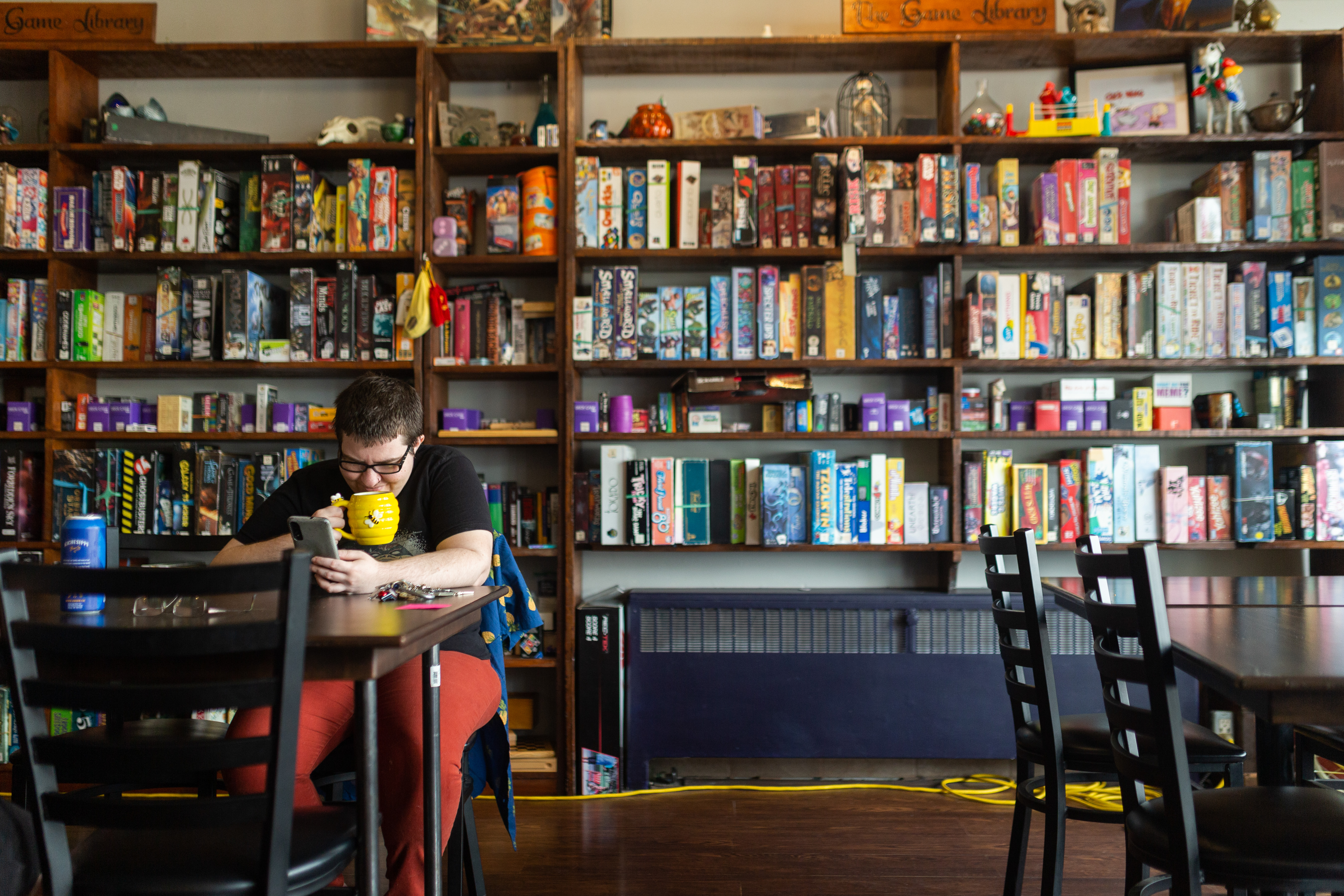 2022 - Brew Wizards - Interior space A person drinking from a mug inside Brew Wizards in downtown Oshawa