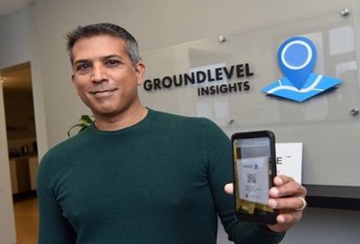 Founder of GroundLevel Insights holding a phone.