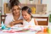 Mother and daughter drawing together. 